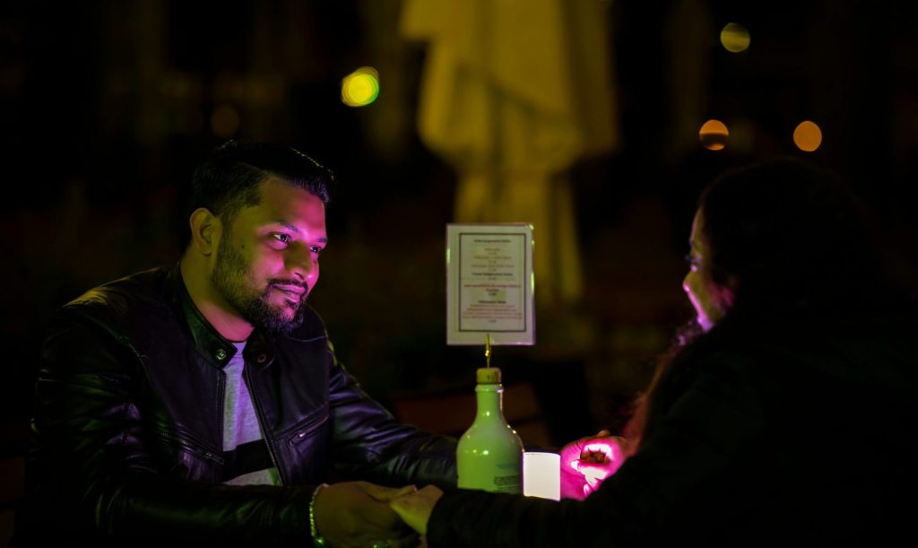 A man sitting at a table with a bottle of wine